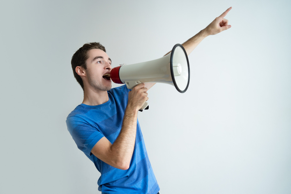 serious-man-shouting-into-megaphone-pointing-away